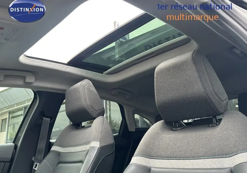 Intérieur de la Citroën C4 2021 avec toit ouvrant, sièges tissu gris et cuir noir vus de l'avant côté conducteur.