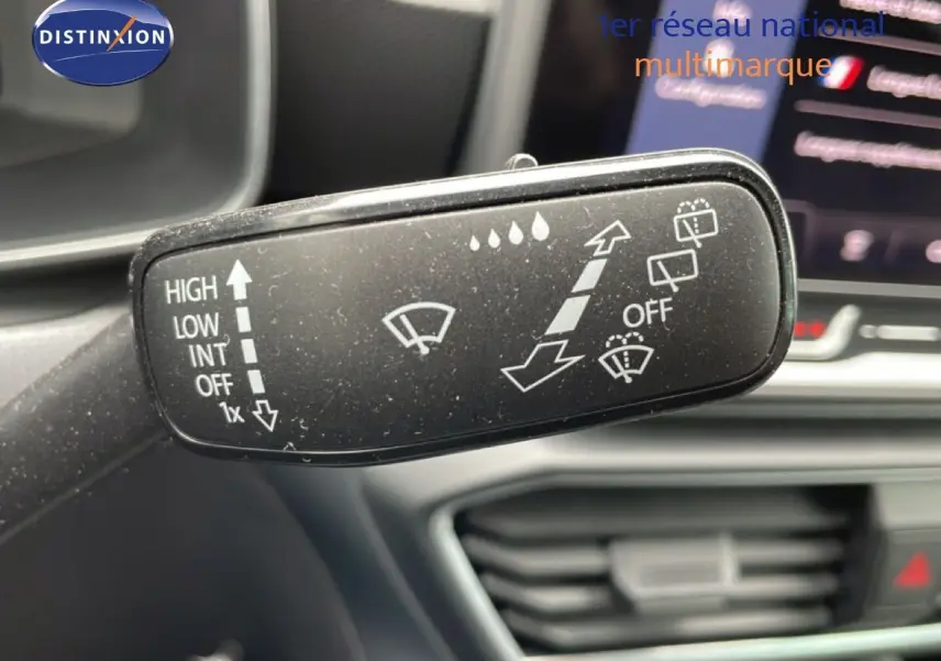 Gros plan sur la commande d’essuie-glace du SEAT LEON ST gris métallique, intérieur avec tableau de bord flou en arrière-plan.