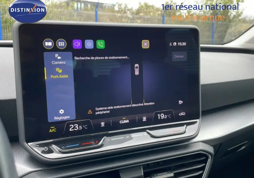 Écran tactile central du SEAT LEON ST gris magnétique, affichant l'assistance au stationnement et la climatisation.
