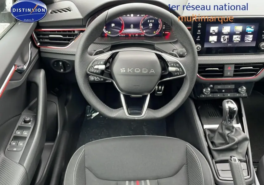 Vue intérieure frontale du Skoda Kamiq 2026, volant sport cuir, tableau de bord numérique et console centrale avec levier automatique.