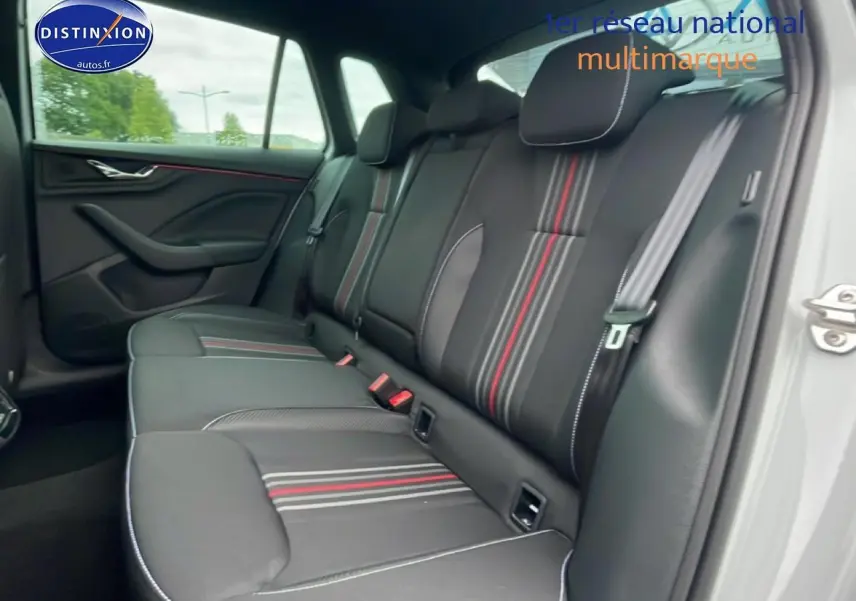 Vue intérieure côté droit sur la banquette arrière noire avec surpiqûres blanches et bandes rouges du Skoda Kamiq blanc nacré.