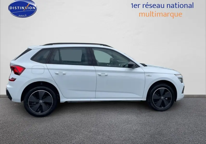 Profil droit d'un Skoda Kamiq blanc nacré 2026 avec jantes noires et toit panoramique en verre.