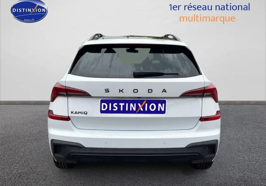Vue arrière d'un Skoda Kamiq blanc nacré avec feux LED et diffuseur noir, sur fond neutre gris.