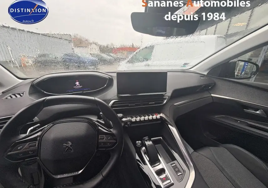 Vue intérieure avant du Peugeot 3008 Hybrid blanc, mettant en valeur le volant compact, l'écran tactile et la console centrale moderne.