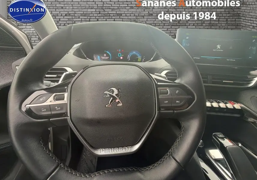 Vue rapprochée du volant cuir noir et du tableau de bord numérique du Peugeot 3008 Hybrid blanc de 2021.