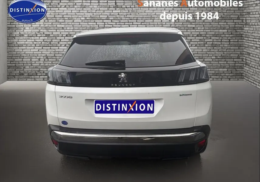 Vue arrière d'un Peugeot 3008 Hybrid blanc avec toit noir et badges distinctifs sur fond de mur en briques.
