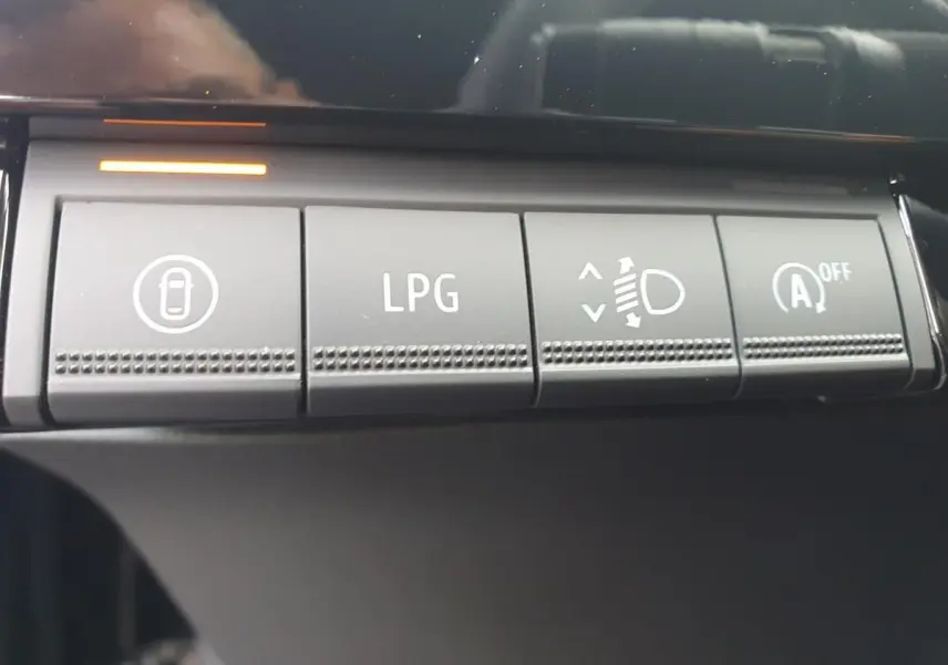 Gros plan sur les boutons de commande intérieurs de la Renault Clio VI noire, dont le bouton LPG pour la bicarburation.