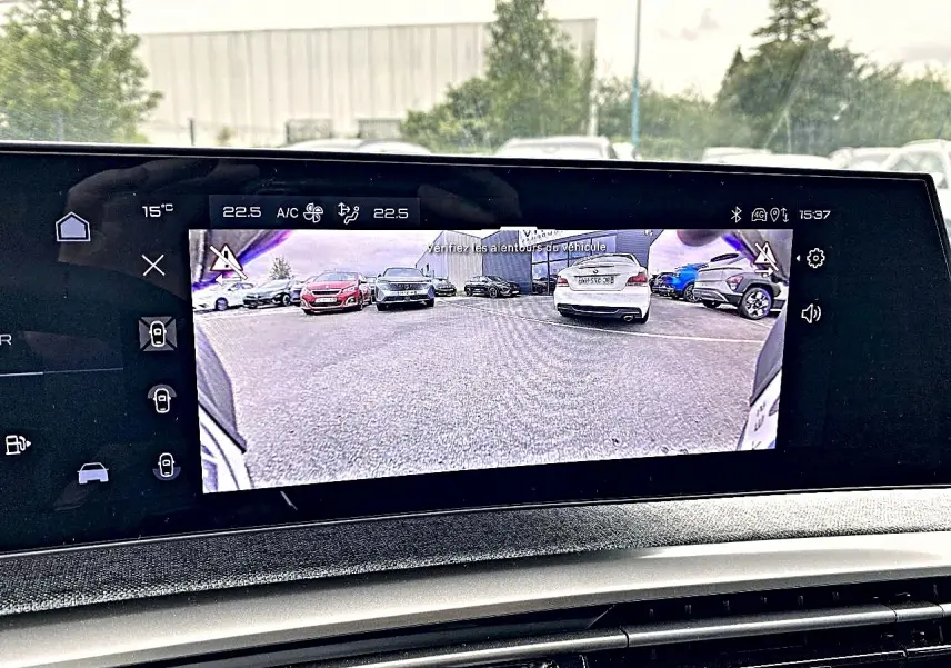 Écran tactile intérieur montrant la caméra de recul du Peugeot 3008 bleu obsession en stationnement.