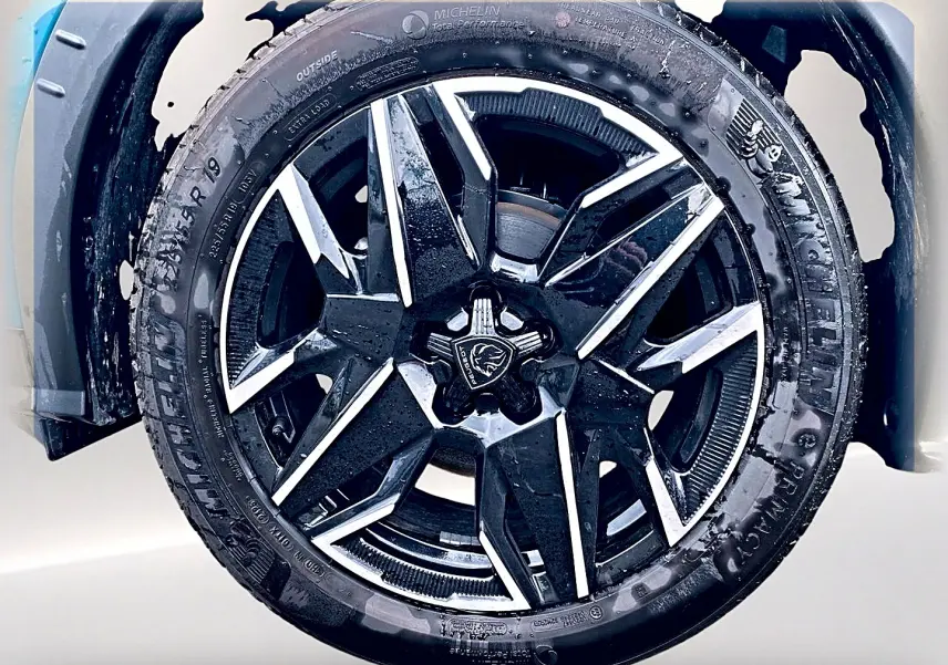 Gros plan sur la jante alu noire et argentée du PEUGEOT 3008 Bleu Obsession, mettant en valeur le logo central.