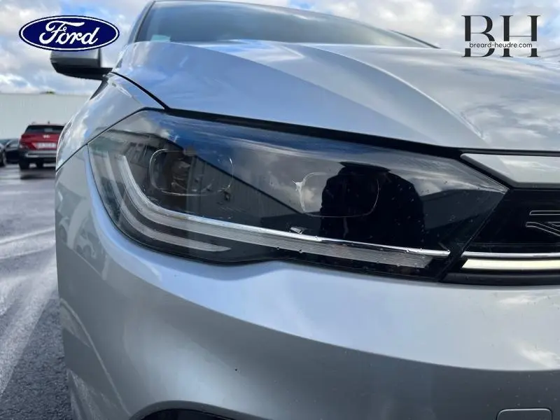 Gros plan sur le phare avant gauche d'une Volkswagen Polo 2022 Reflet d'Argent métallisé avec calandre noire.