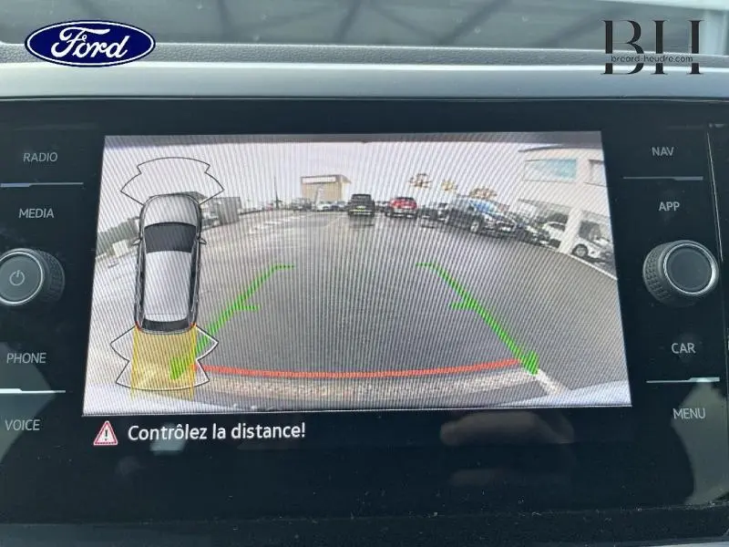 Image de l'écran de la caméra de recul d'une Volkswagen Polo 2022, affichant la vue arrière avec repères verts et rouges.