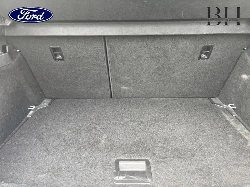 Coffre vide en tissu gris foncé d'une Volkswagen Polo 2022, vue intérieure arrière sans éléments distinctifs visibles.