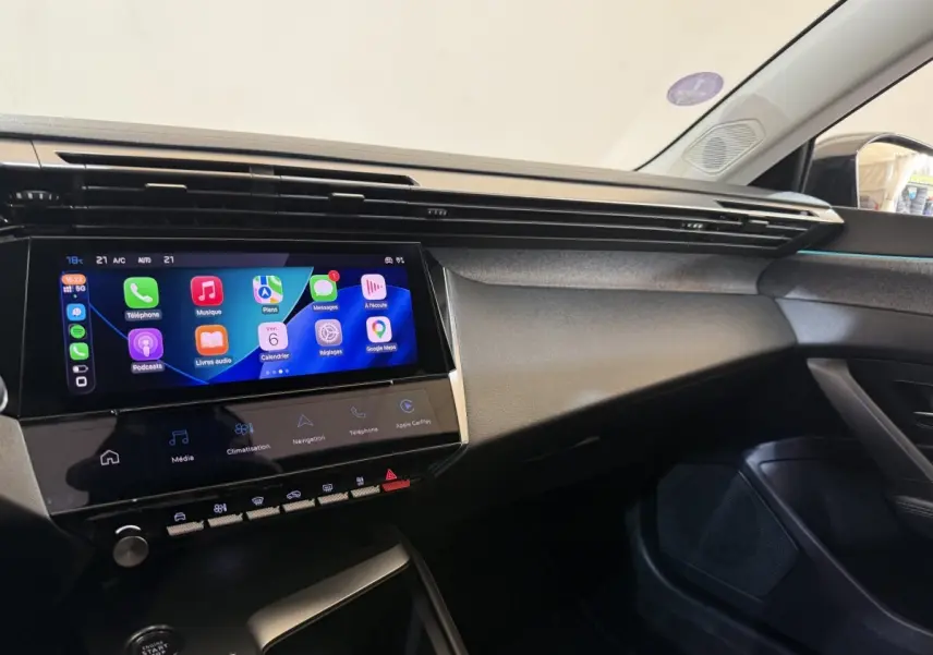 Vue intérieure côté passager du tableau de bord de la Peugeot 308 gris foncé avec écran tactile multimédia allumé.