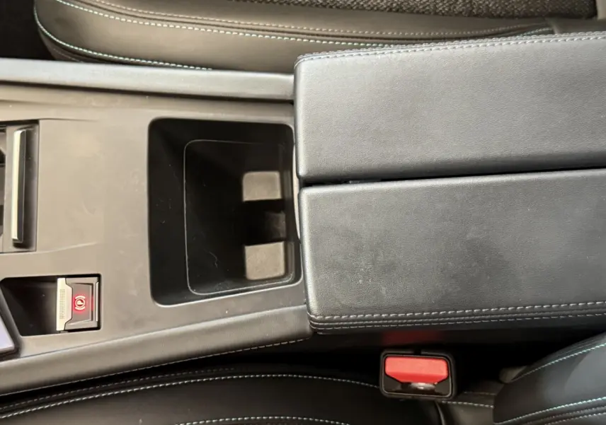 Vue rapprochée de la console centrale noire avec frein à main électrique et accoudoir en cuir de la Peugeot 308 gris foncé.