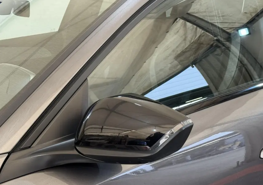 Rétroviseur côté conducteur noir brillant sur Peugeot 308 gris foncé, vue rapprochée du côté gauche.