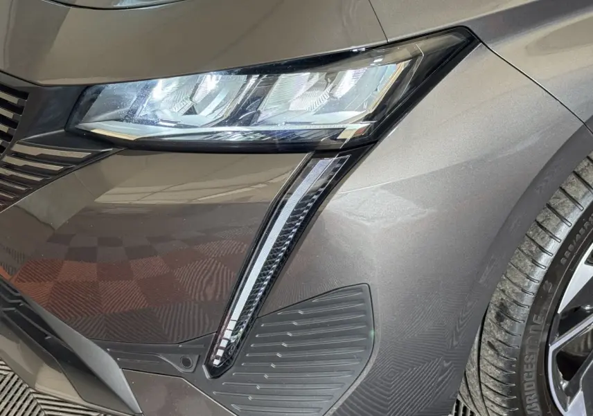 Gros plan sur le phare avant droit gris foncé du Peugeot 308 SW avec éclairage LED et détails du pare-chocs.