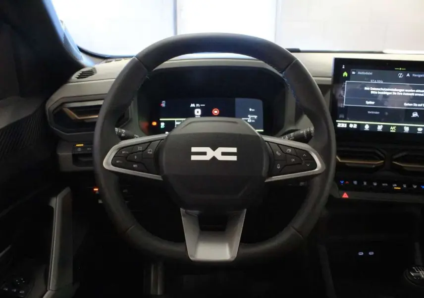 Vue frontale du volant cuir noir du Dacia Bigster 2026 avec tableau de bord digital et écran tactile central.