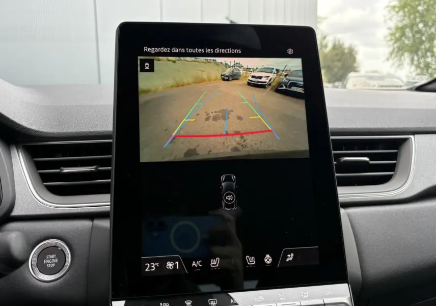 Écran central tactile du Renault Captur noir étoile 2025 montrant la caméra de recul avec lignes de guidage colorées.