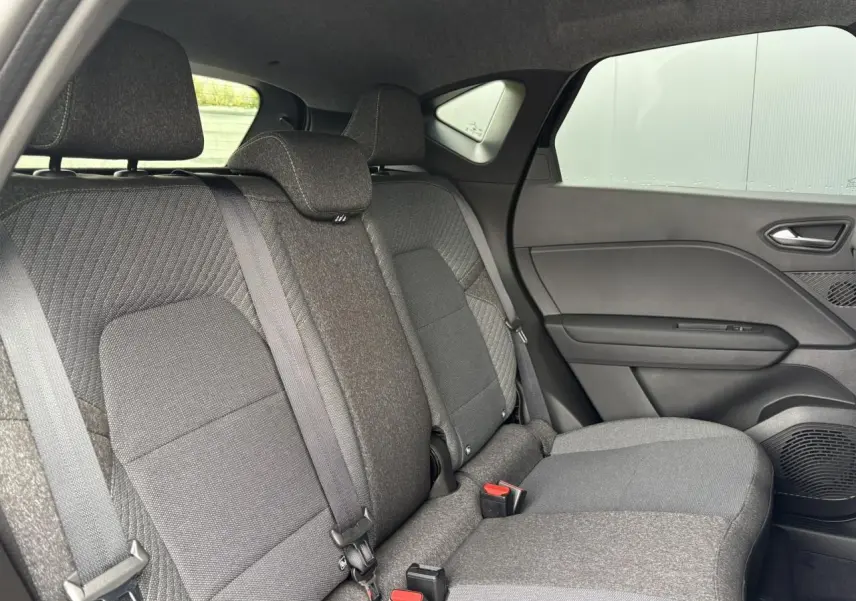 Vue intérieure sur la banquette arrière grise du Renault Captur 2025, avec ceintures et appuis-tête visibles côté droit.