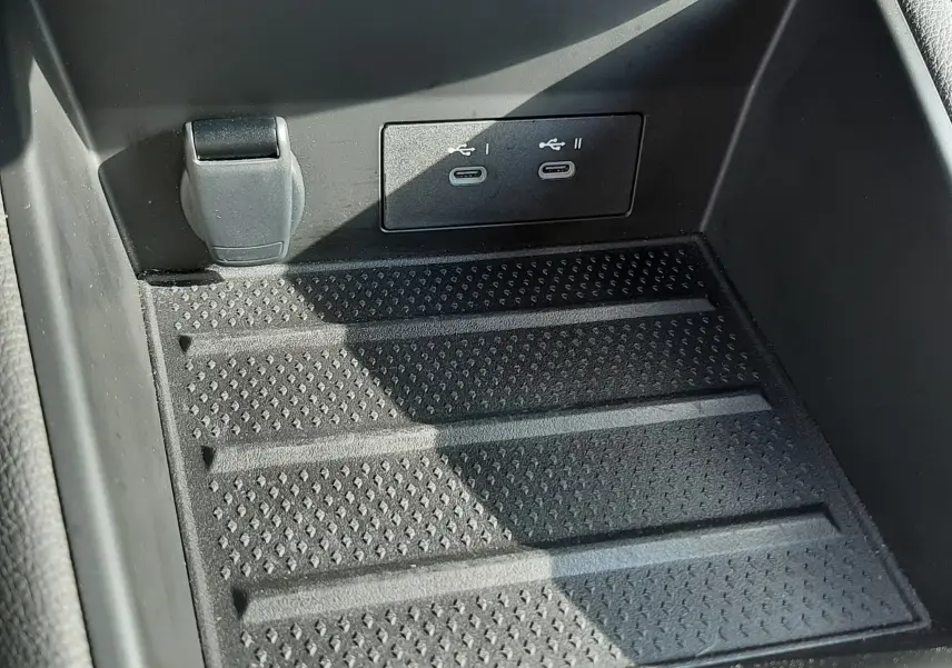 Gros plan sur la console centrale noire du Renault Captur 2024, montrant deux ports USB-C et une prise 12V.