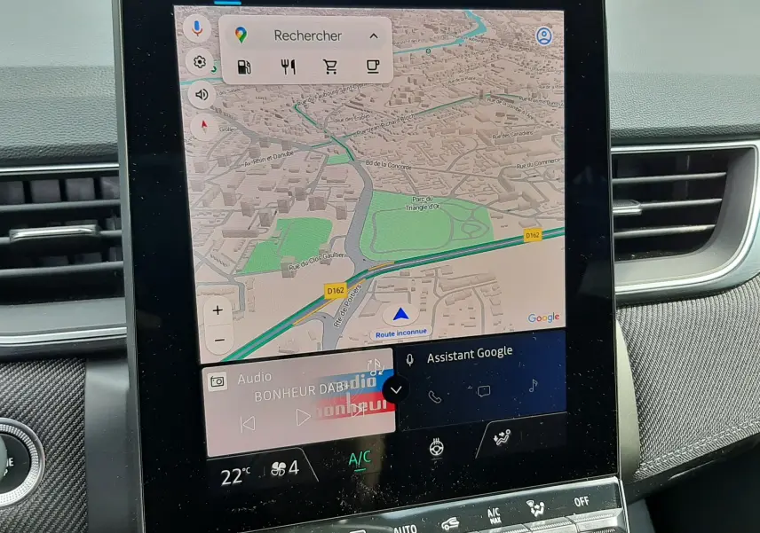 Écran tactile central du Renault Captur hybride 2024 affichant la navigation Google Maps et commandes climatisation.
