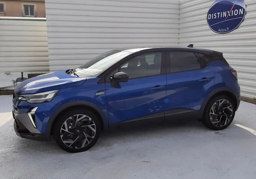 Renault Captur 2024 bleu Iron avec toit noir, vue de profil côté gauche, jantes alliage et vitres teintées.