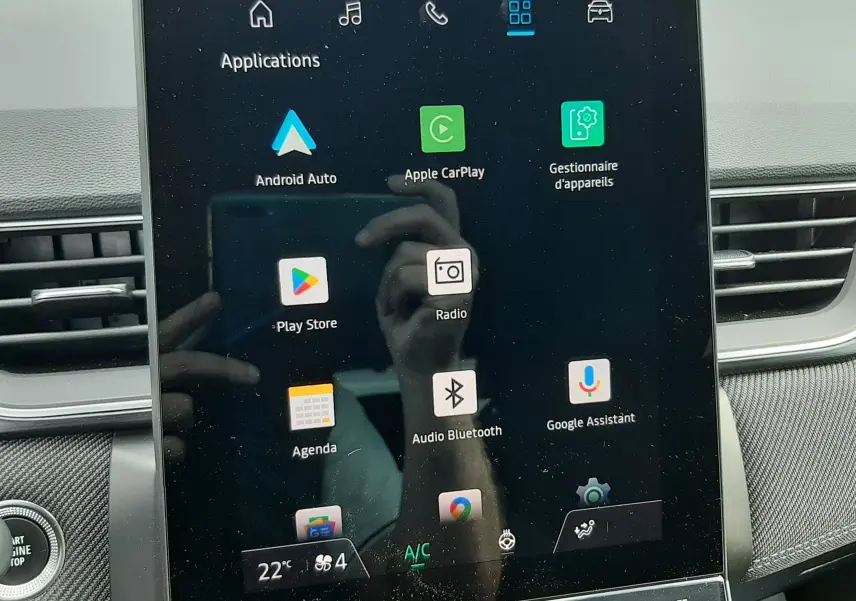 Écran tactile central du Renault Captur 2024 affichant les applications Android Auto et Apple CarPlay, intérieur noir.