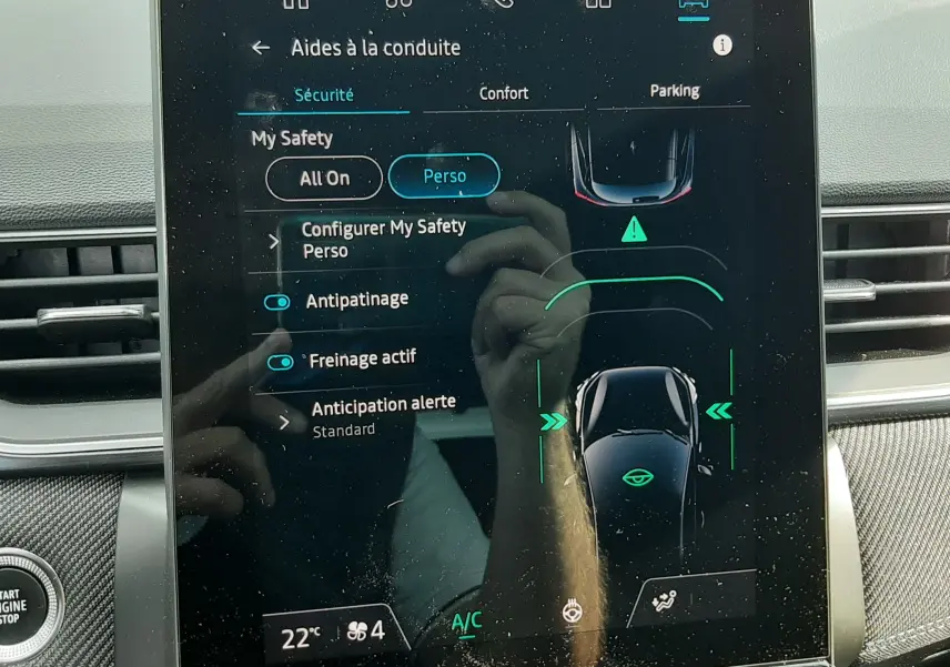Écran tactile central du Renault Captur 2024 affichant les aides à la conduite et la climatisation, intérieur noir.