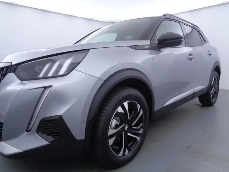 Peugeot 2008 gris Artense vue 3/4 avant droit mettant en valeur les phares LED et jantes alu noires.