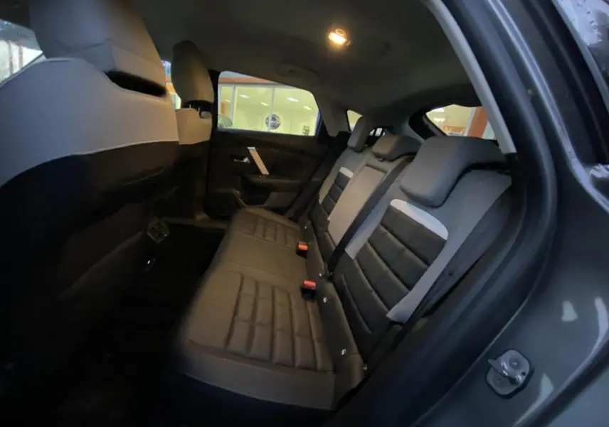 Vue intérieure côté droit des sièges arrière en cuir noir et gris d'une Citroën C4 2025 gris foncé.