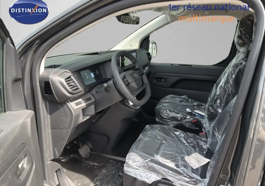 Intérieur avant du Citroën Jumpy gris titane, vue côté conducteur avec sièges protégés par film plastique.