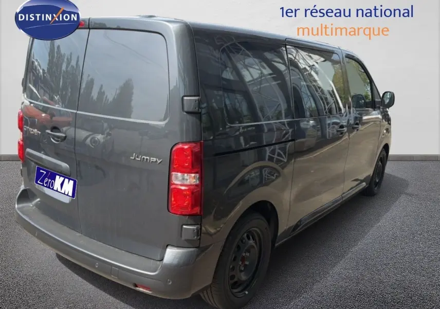Vue 3/4 arrière droite d’un Citroën Jumpy cabine approfondie gris titane métallisé avec vitres teintées et feux arrière rouges.