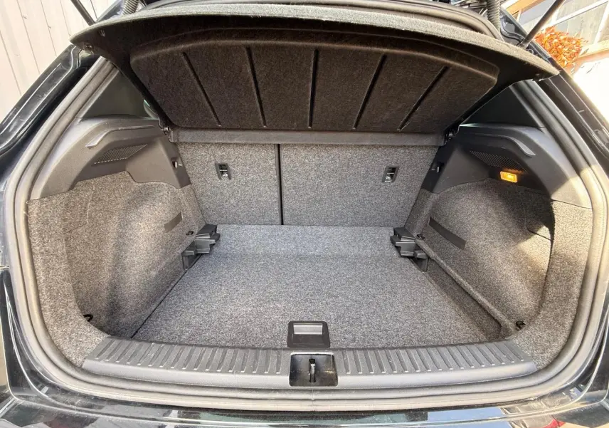 Coffre ouvert vu de l'arrière d'une SEAT Arona 2022 noire, avec intérieur gris et éclairage latéral allumé.