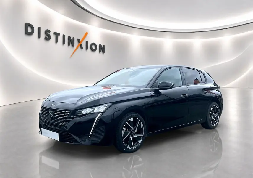 Peugeot 308 noire vue en 3/4 avant droit, avec phares LED et jantes alliage distinctives dans un showroom lumineux.