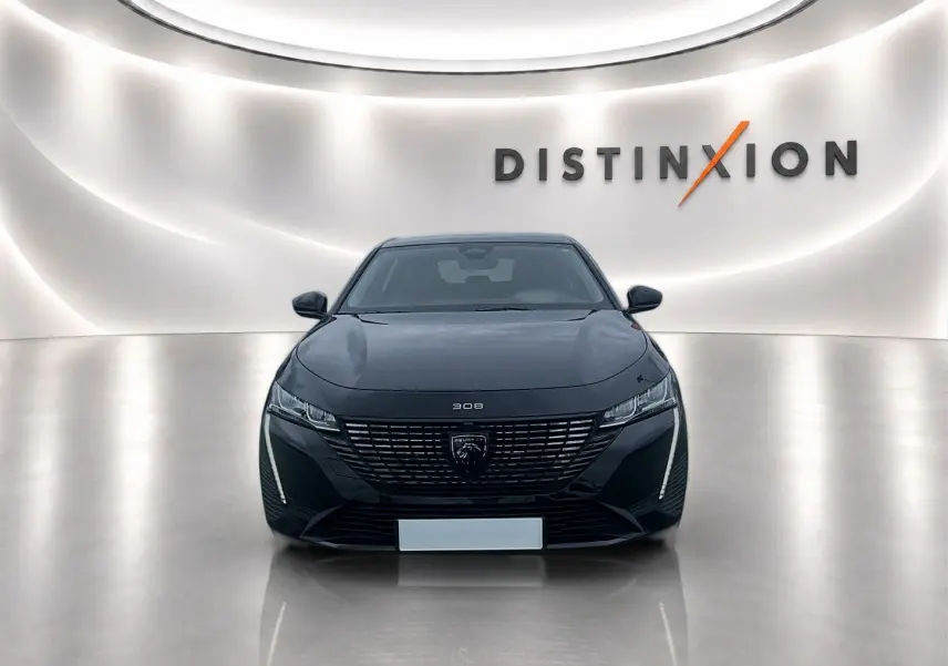 Peugeot 308 noire vue de face dans un showroom lumineux avec logo Distinxion en arrière-plan.