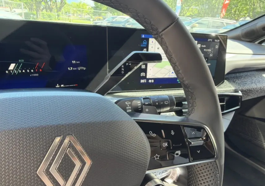 Gros plan sur le volant cuir grainé et le tableau de bord numérique avec écran tactile de la Renault Clio blanc glacier 2026.