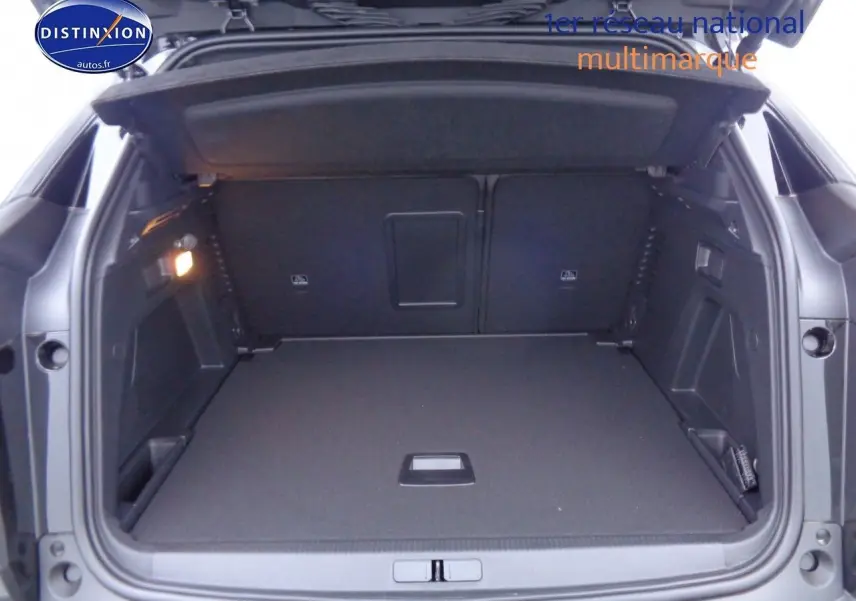 Coffre ouvert du Peugeot 3008 noir métal 2023, montrant un espace de chargement spacieux et bien éclairé.