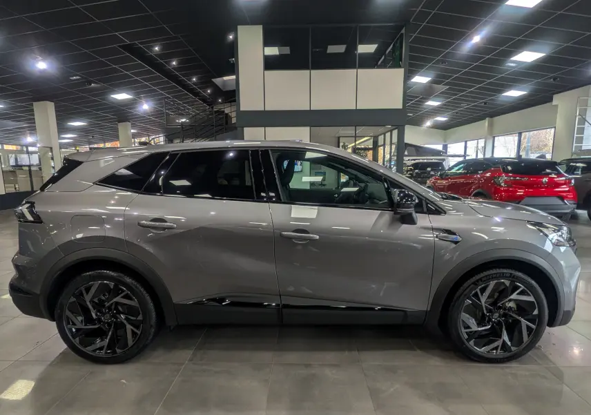 Profil côté gauche du Renault SYMBIOZ gris Cassiopé, version hybride Esprit Alpine, avec jantes noires distinctives en showroom.