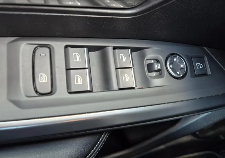 Vue rapprochée des commandes de lève-vitres et réglage des rétroviseurs côté conducteur du Peugeot 3008 gris clair 2024.