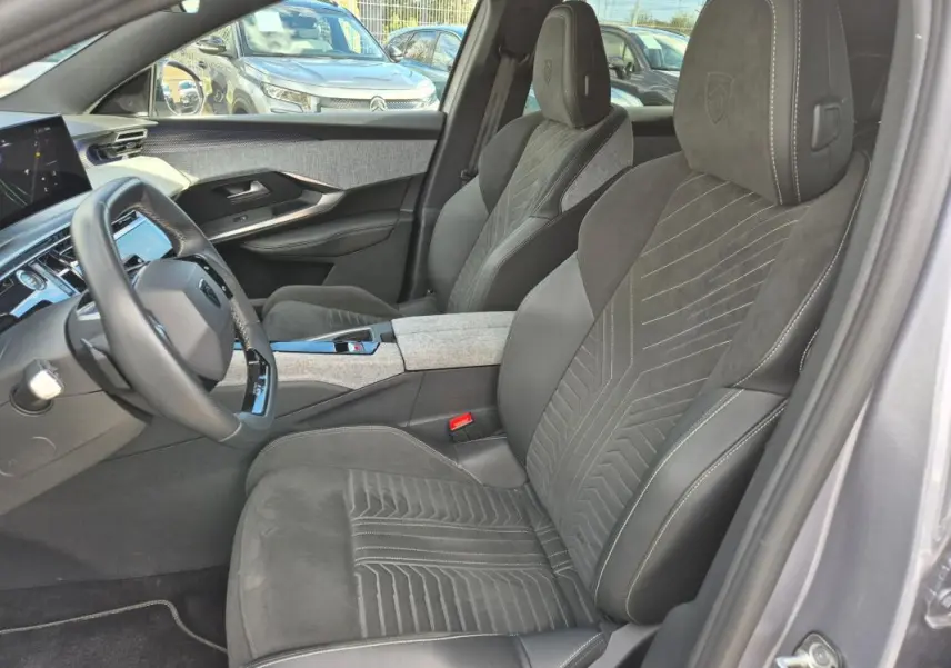 Vue intérieure côté conducteur du Peugeot 3008 Hybrid 136 e-DCS6 GT 2024 gris clair, avec sièges en alcantara et cockpit numérique.