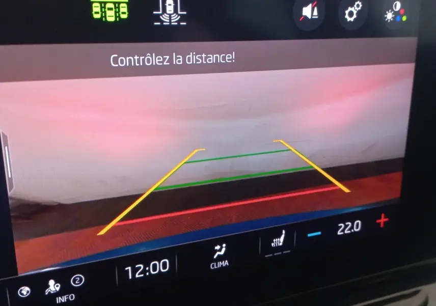 Écran tactile central de la Skoda Octavia 2022 bleu montrant la caméra de recul avec lignes de guidage colorées.