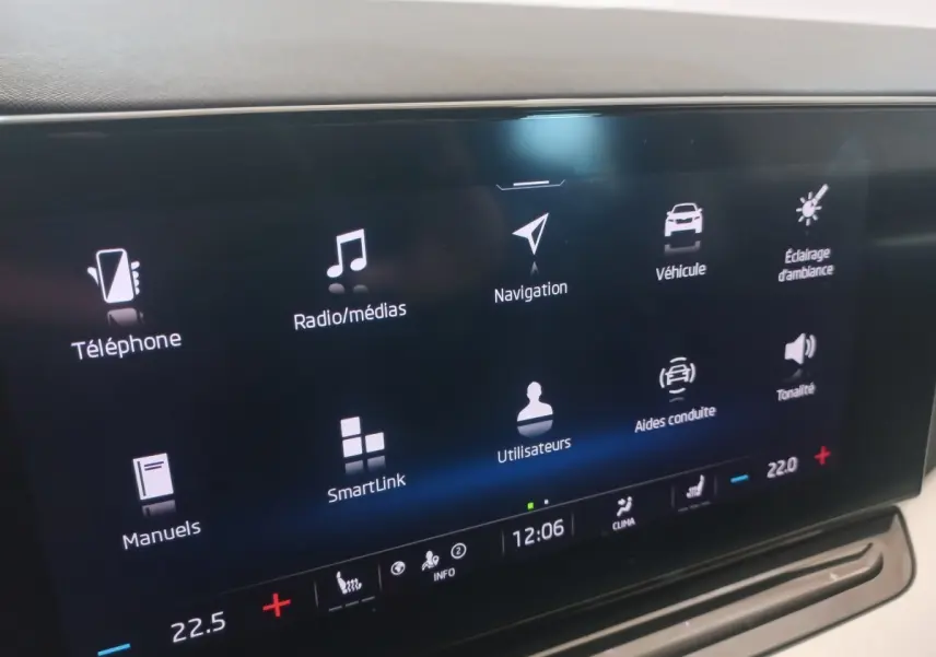 Écran tactile central de la Skoda Octavia bleu, affichant les menus de navigation et médias en intérieur.