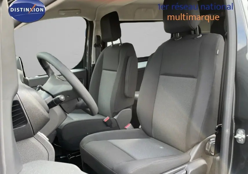 Vue intérieure côté conducteur du Citroën Jumpy Cabine Approfondie gris titane, avec sièges tissu gris et volant multifonction.