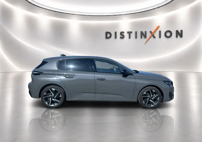 Profil côté gauche de la Peugeot 308 2025 gris artense avec jantes alu, vitres surteintées et lignes épurées.