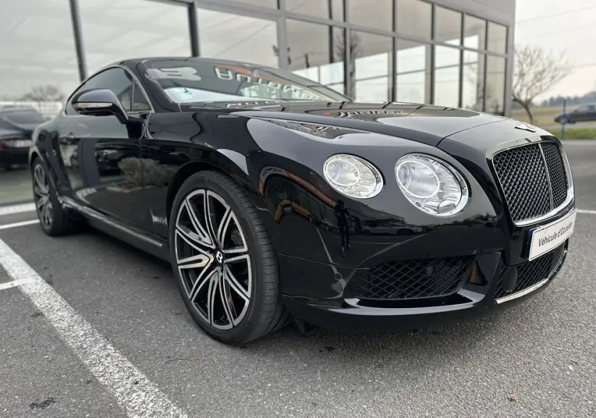 Bentley Continental GT Mulliner noire vue en 3/4 avant droit, avec jantes distinctives et calandre chromée.