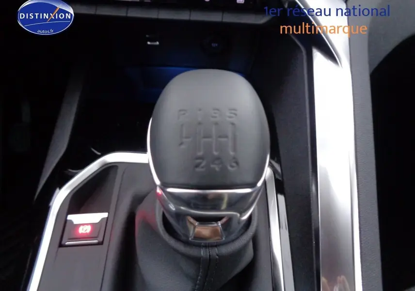 Gros plan sur le levier de vitesses manuel noir du Peugeot 3008 2023 finition Allure Pack, entouré de détails chromés.