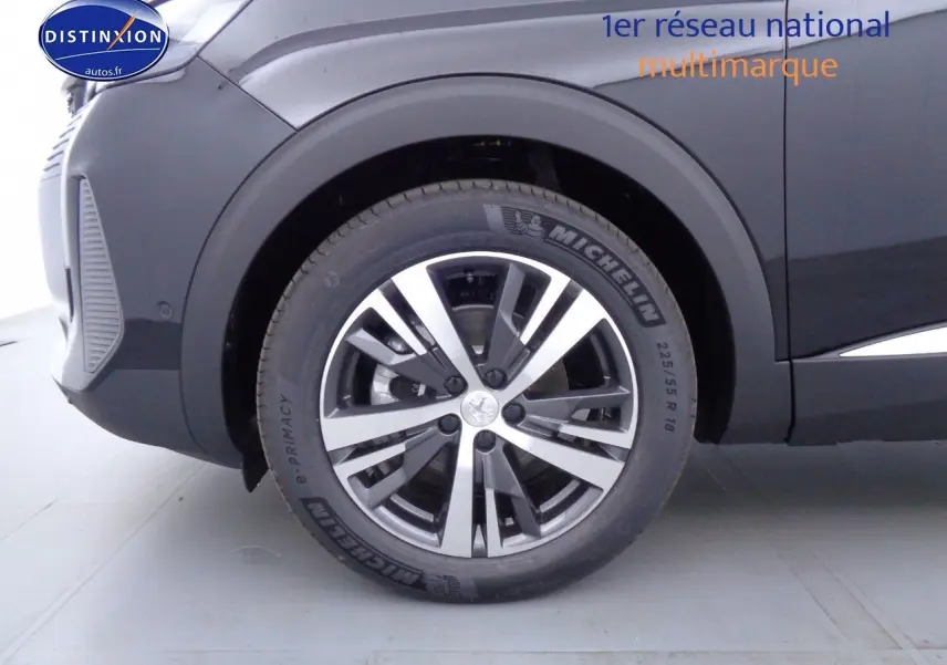 Gros plan sur la roue avant gauche du Peugeot 3008 noir métal 2023, mettant en valeur la jante aluminium bicolore et le pneu Michelin.
