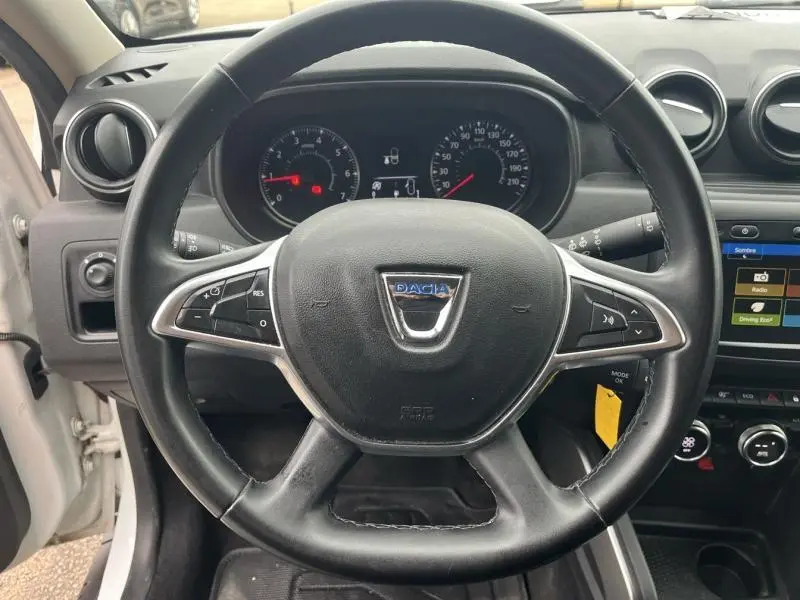 Vue rapprochée du volant multifonction noir du Dacia Duster 2019 avec tableau de bord et écran tactile visibles.