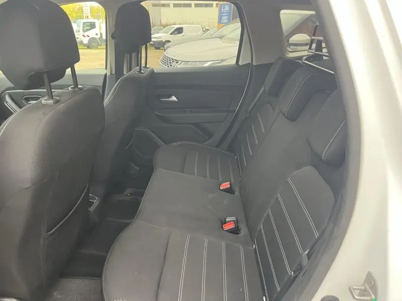Vue intérieure côté droit sur la banquette arrière noire du Dacia Duster 2019 Blanc Glacier avec appuis-tête réglables.