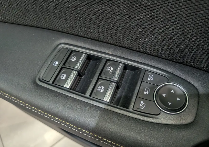 Panneau de commandes des vitres électriques et rétroviseurs sur la porte intérieure d'une Renault Symbioz gris Cassiopé.